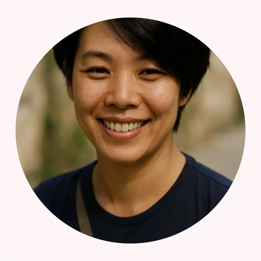 Smiling portrait of Saiko, short dark hair, wearing a navy shirt, in a circular frame